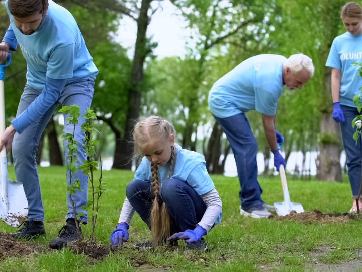 a multi generational family planting trees during a family volunteer vacation