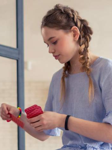 Girl looking down at playing cards in her hand and discarding one