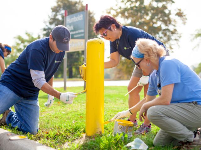 Volunteers painting a pole at an event