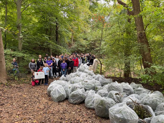 NPLD volunteers at Dumbarton Oaks stand with bags full on invasive species removed