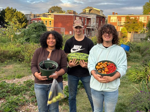 McCaskey High School students stand in the school's vegetable garden with fresh picked produce.