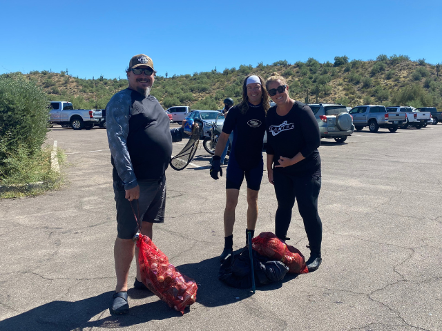 Three people standing in a parking lot smiling