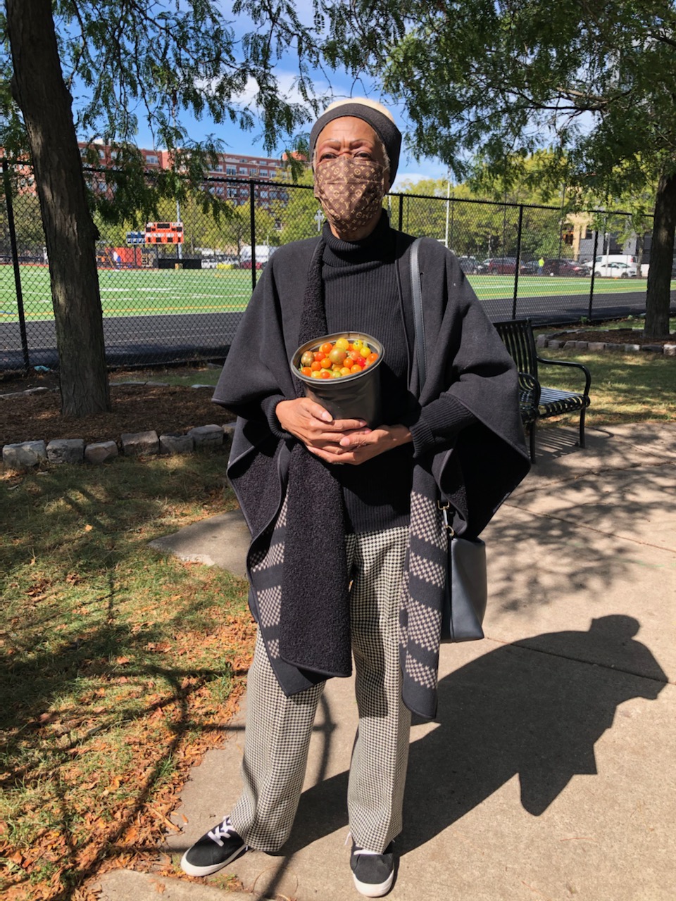 Woman holding harvested tomatoes from Skinner Park in Chicago.