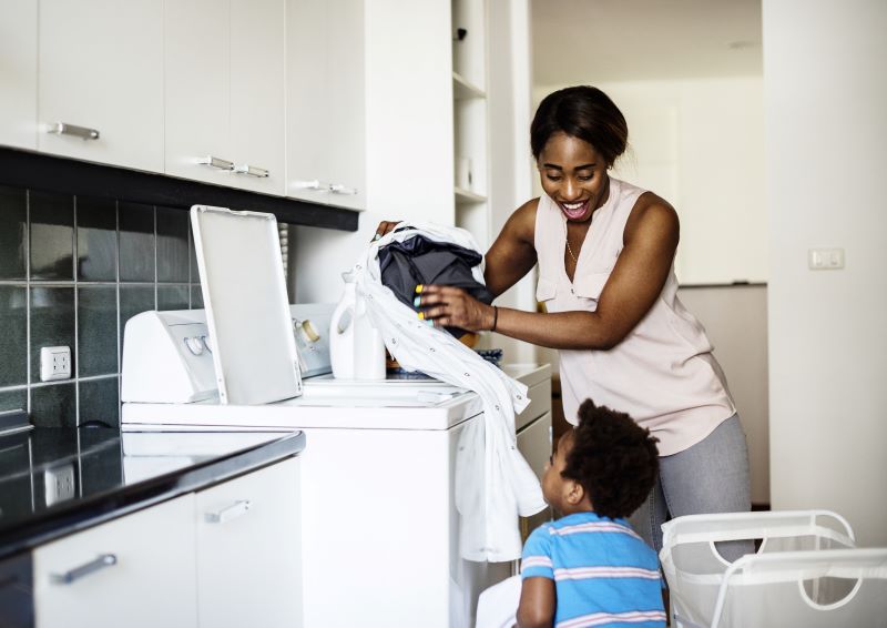 mother and son doing laundry in cold water to save energy