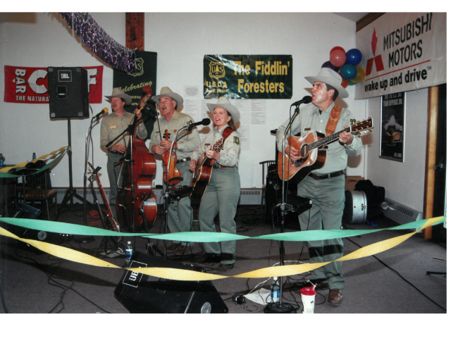 Forest Service band playing guitars on stage