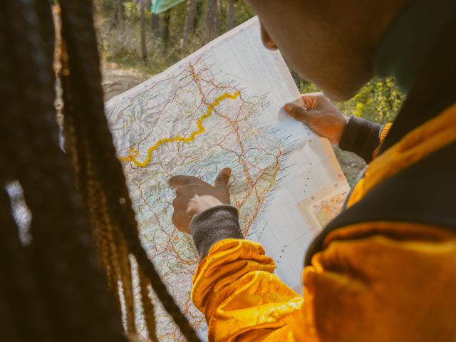 Person looking at a map pointing