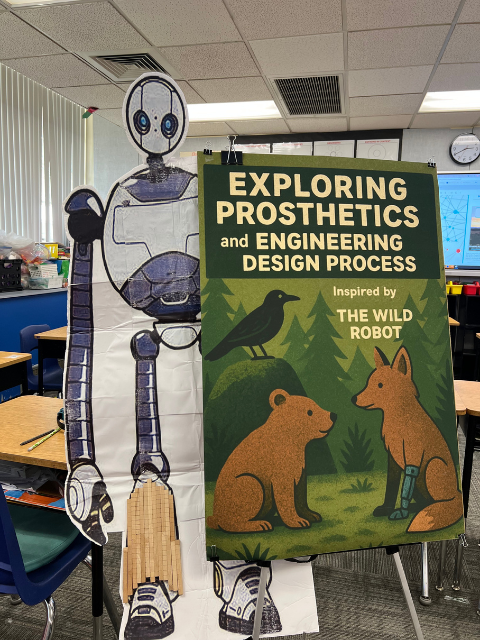 Cardboard robot near a sign with Exploring Prosthetics written on it.
