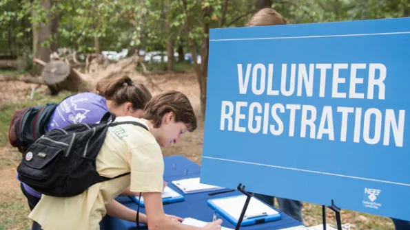 Two young women signing up for an NPLD volunteer event