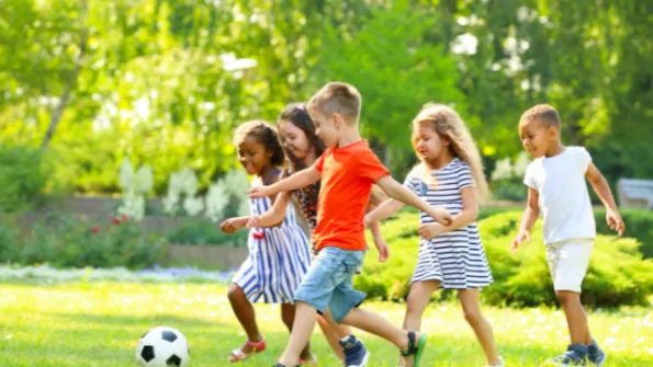 Children outdoors playing soccer