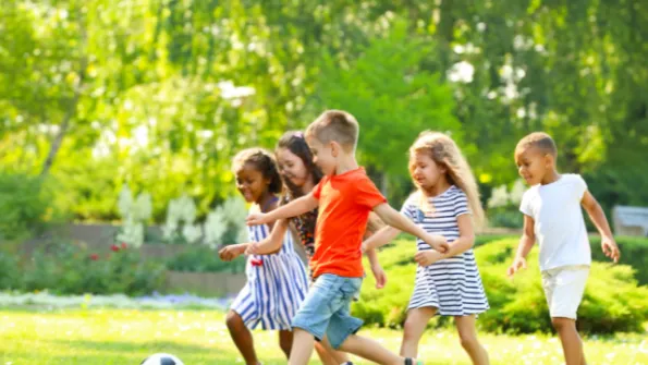 Children outdoors playing soccer