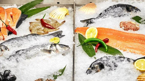 Photo of various seafoods on ice in a supermarket fridge