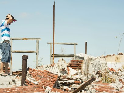 Man surveying destruction from a natural disaster