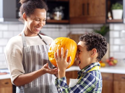 Mom and kids playing and carving pumpkins