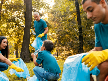 group of diverse people, one in a wheelchair, collecting litter in a forested area