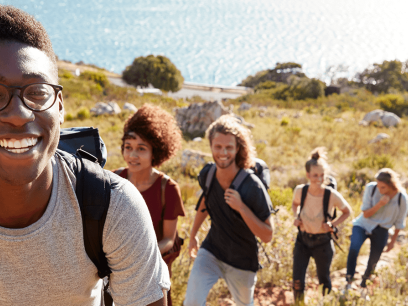 group of diverse young people hiking up a mountain on public land