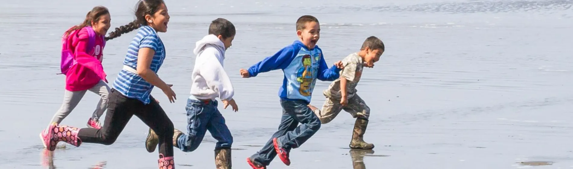 photo of students running on the beach