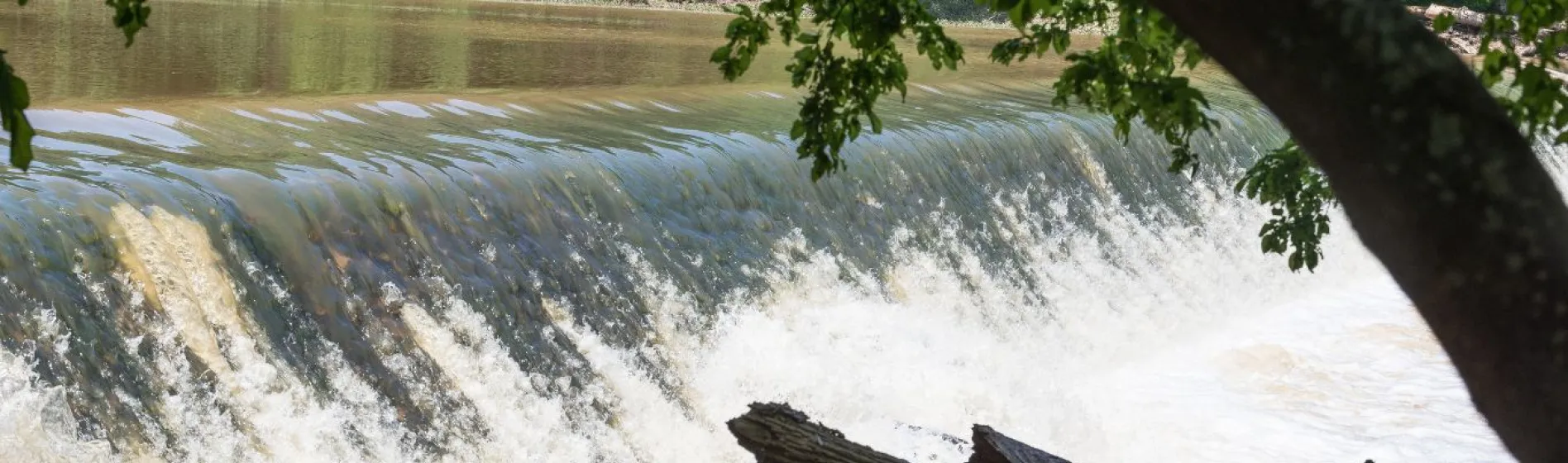 water flows over a break in the middle of a suburban river