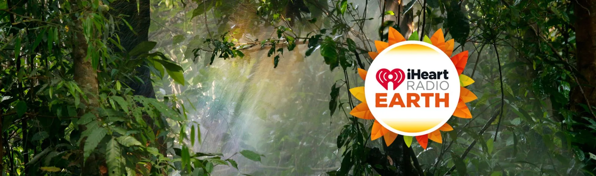 iHeart Radio Earth logo with photo of jungle in the background