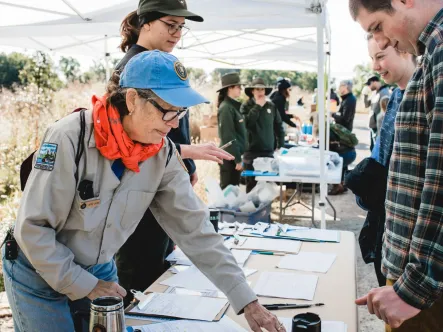 a national park employee welcomes volunteers during a national public lands day events