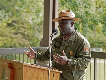 a national park ranger speaks at a podium during a national public lands day event