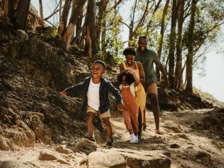 parents with two children hiking on a trail in the woods