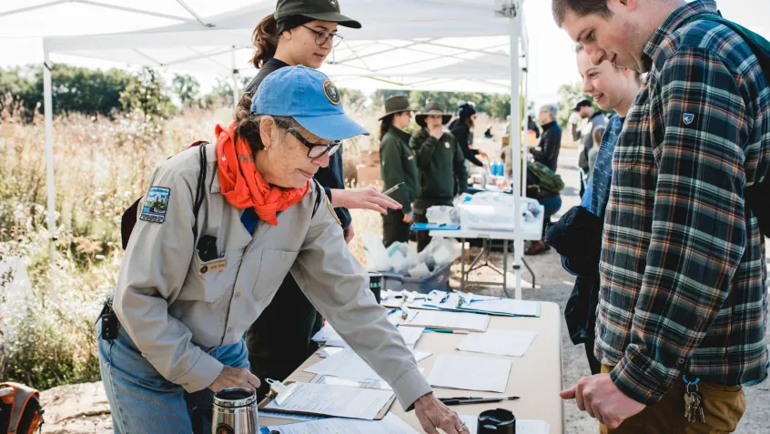 a national park employee welcomes volunteers during a national public lands day events