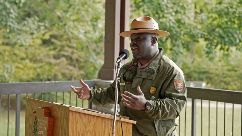 a national park ranger speaks at a podium during a national public lands day event