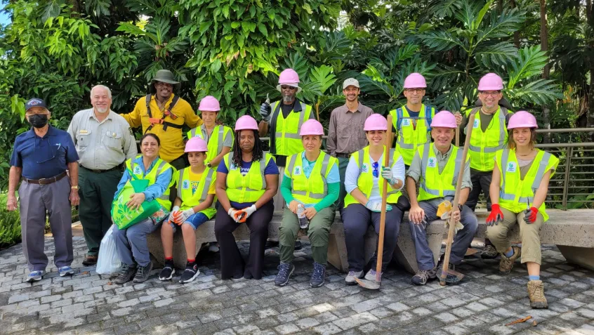 A group of National Public Lands Day volunteers in reflector vests sit for a group picture at El Yunque National Forest in Puerto Rico