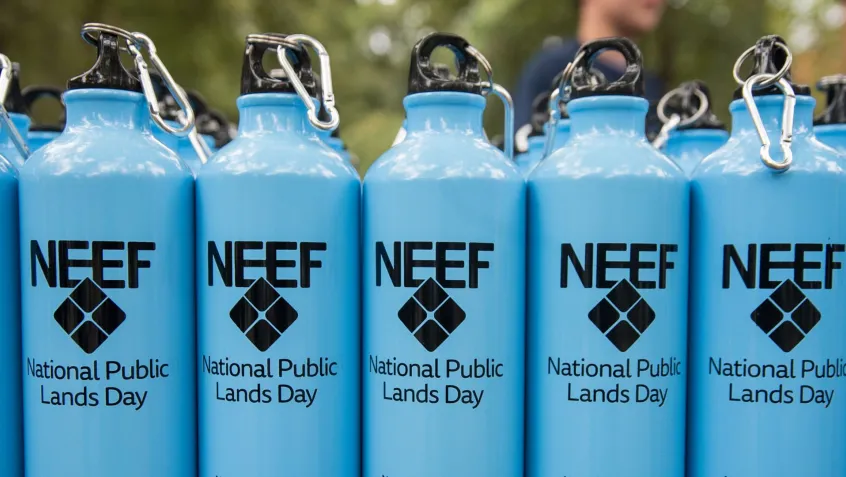 blue reusable water bottles with the NEEF National Public Lands Day logo on them lined up next to one another