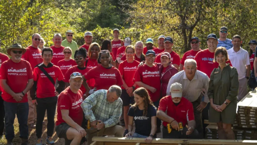 Toyota employees and NEEF in front of a wood boardwalk that is being built