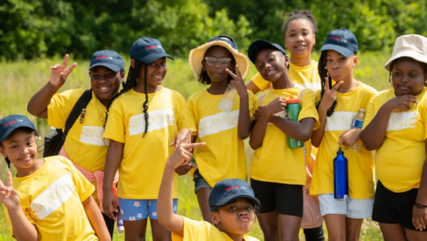 Young girls in a group smiling outdoors