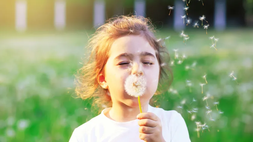 Girl blowing dandelion