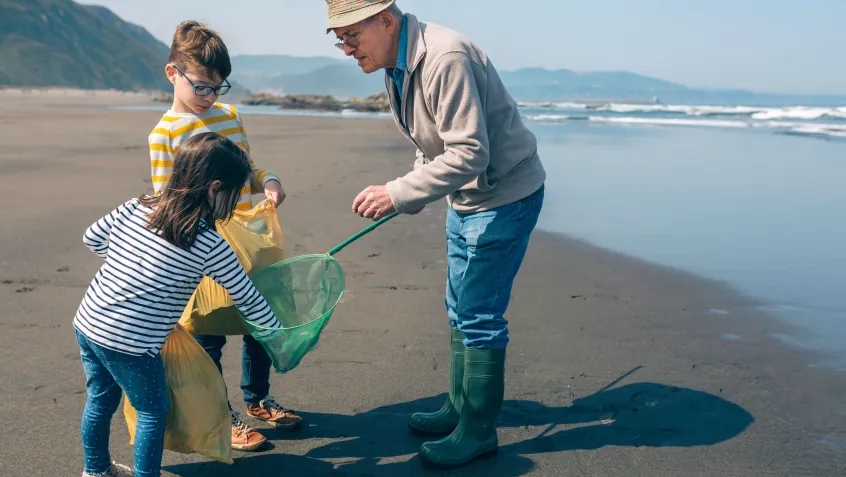 Kids and their grandfather at a beach clean-up