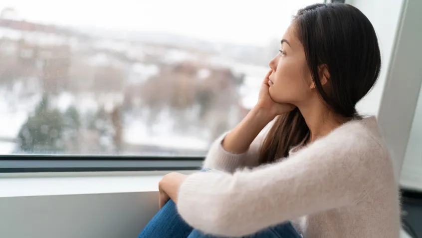 Seasonally depressed woman staring out the window
