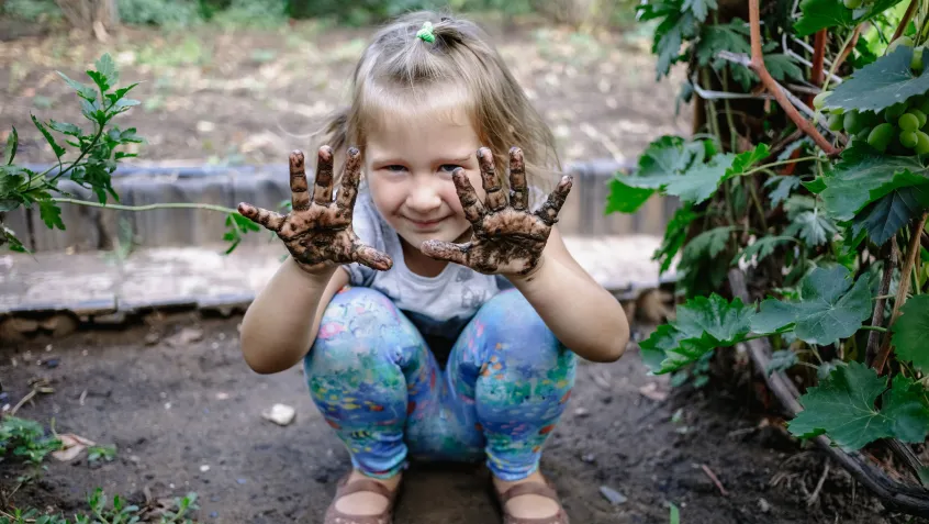Girl in a garden in the mud