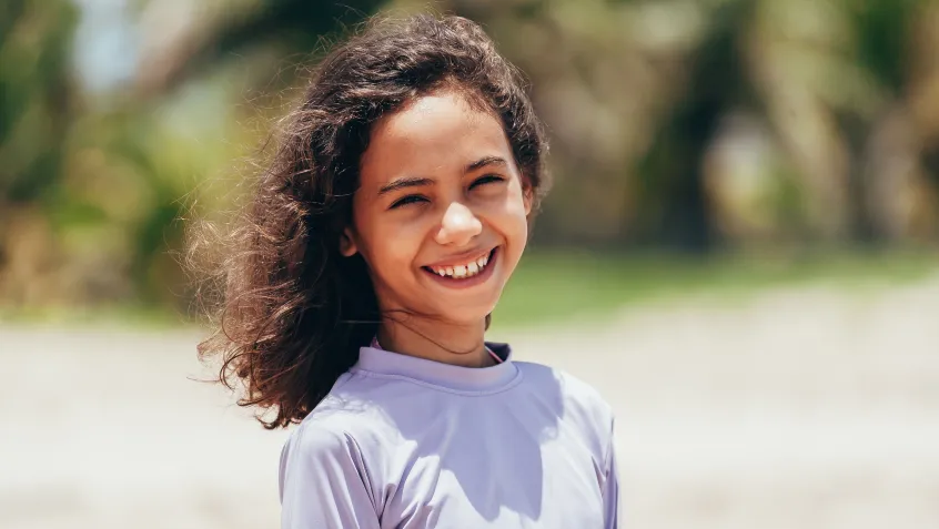 Girl on the beach in protective sunwear 