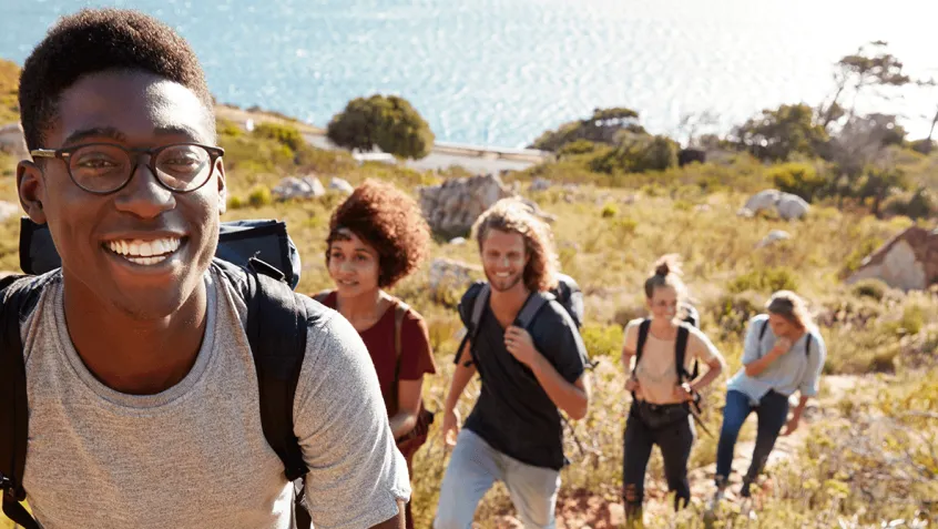 group of diverse young people hiking up a mountain on public land