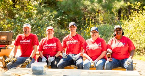 a group of Toyota volunteers sits on an accessibility boardwalk trail
