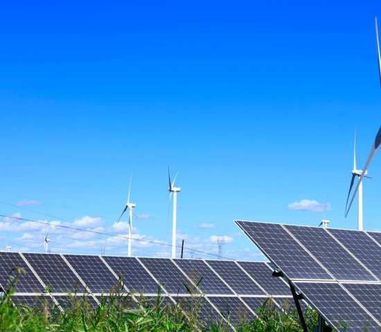 photo of solar panels in field with wind turbines sustainability