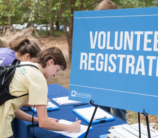 People signing up near a volunteer registration sign