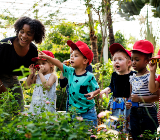 Teacher with young students in an outdoor setting