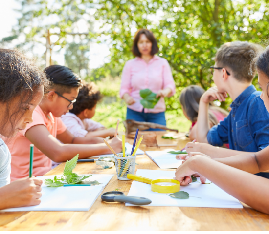 Teacher outside with students at a table