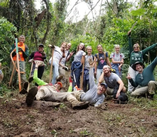 group of National Public Lands Day volunteers smiling with excited expressions while working in the jungle