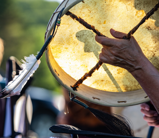 Person holding tambourine with feather
