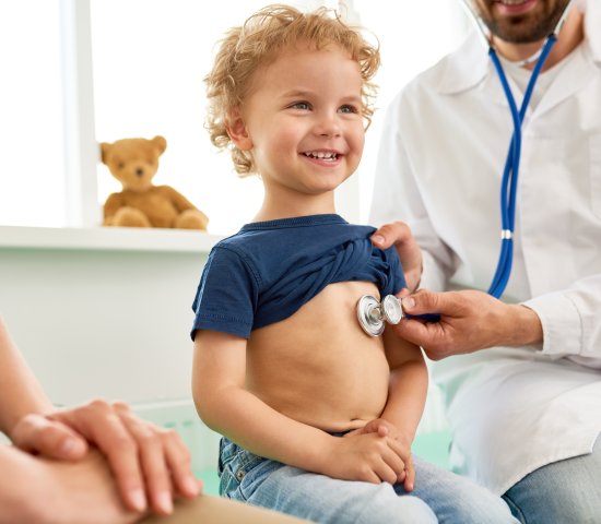 Doctor with stethoscope on child's chest 
