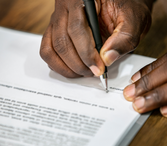 hand with pen signing document