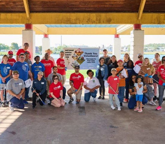 a group of NPLD volunteers stand for a group photo in front of sign National Public Lands Day, Thank You Volunteer, Fish Trap Lake