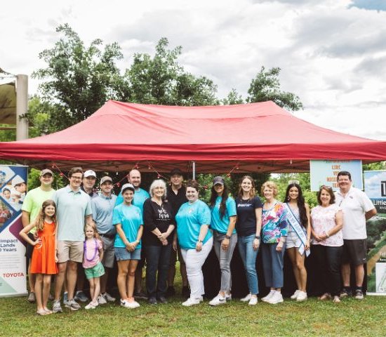 a group of officials from Toyota, NEEF and Park Along the River stand together at the Parkapalooza event in New Albany, MS