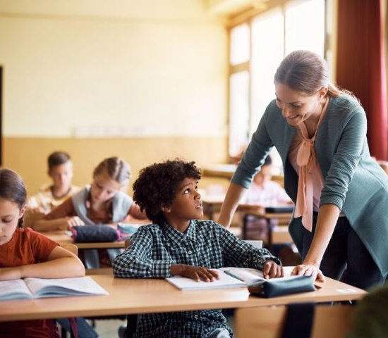 a teacher smiles at a student who looks concerned