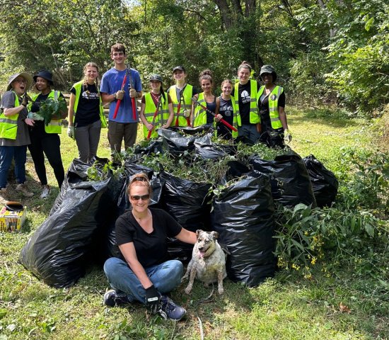 volunteers standing around a mound of trash bags after collecting invasive species on National Public Lands Day